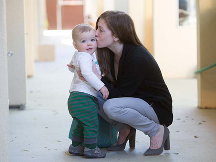 mom kissing carsick toddler