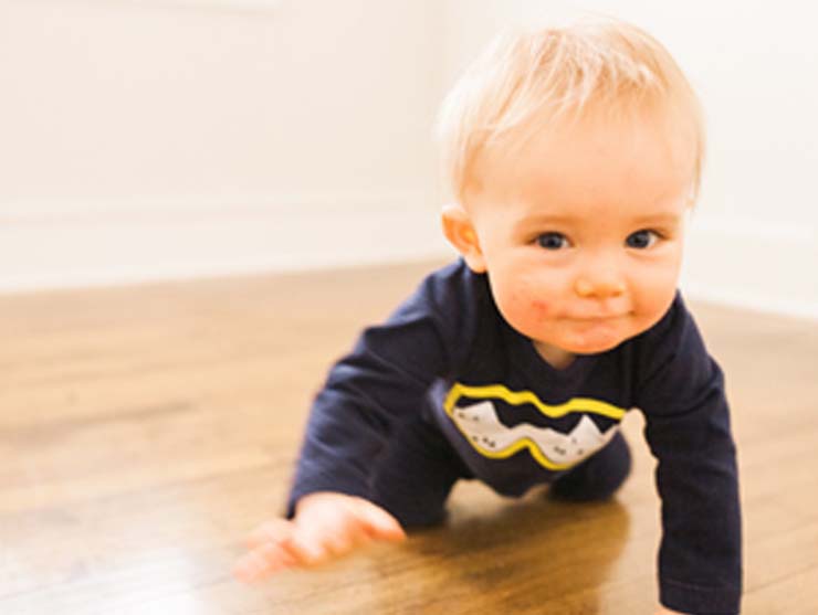baby beginning to crawl across the floor