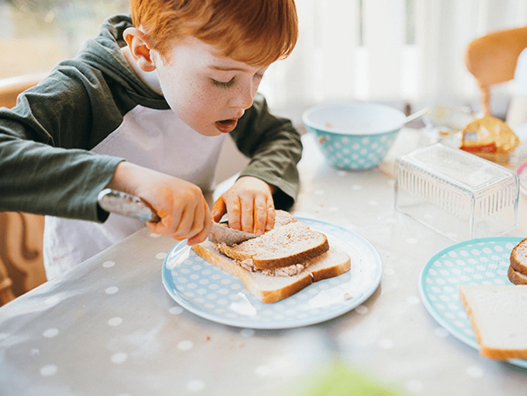 Boy cutting a sandwich