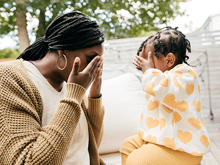 Mom and young girl covering their eyes.