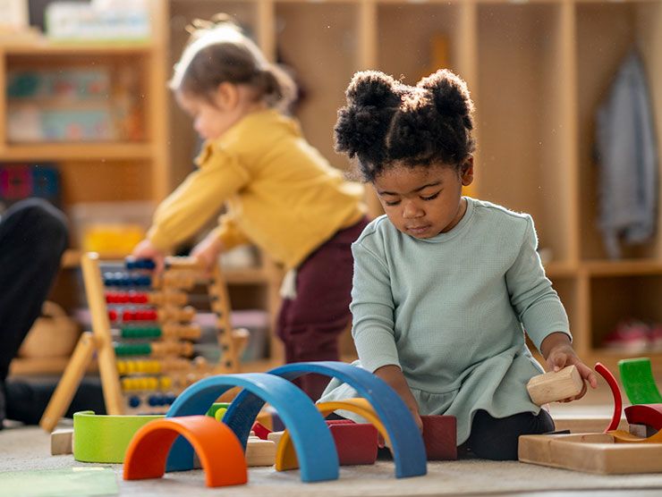 A toddler child playing with toys in a classroom setting.