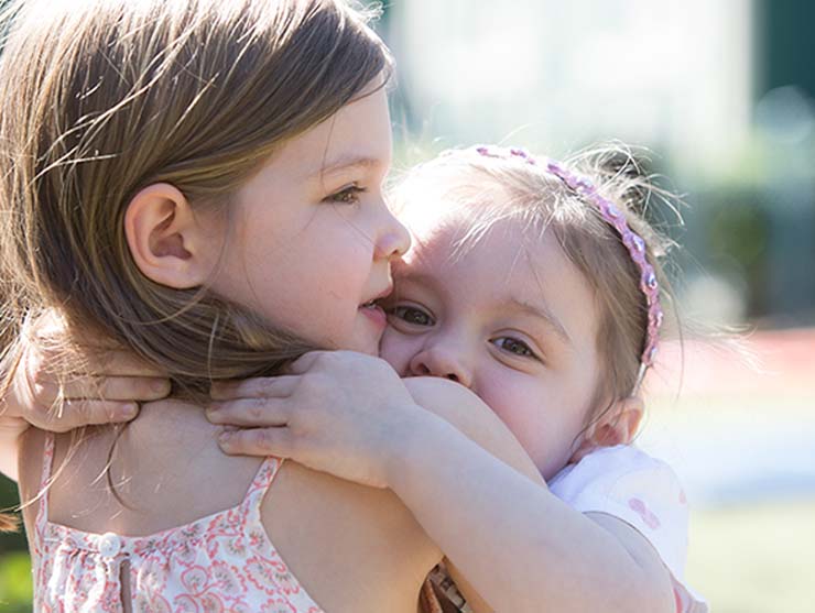 sisters hugging outside