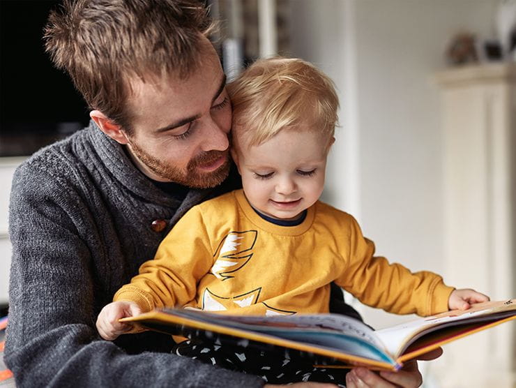 A father with his son reading a story. 