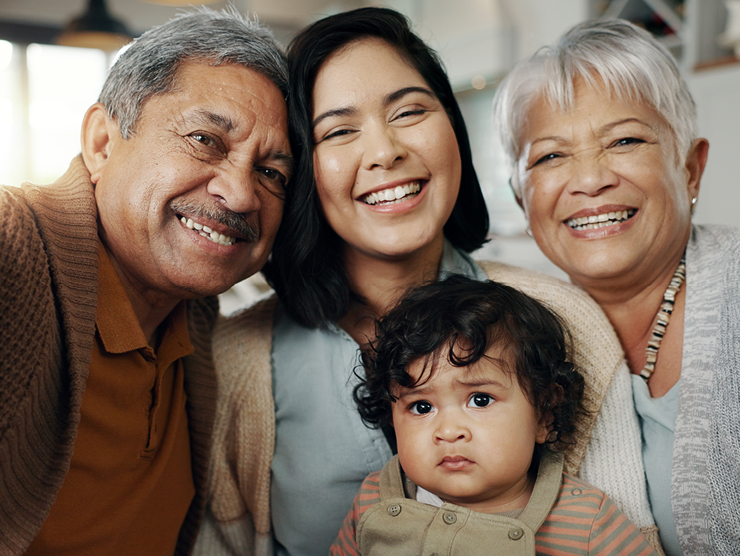 A family with 3 different generations smiling at camera