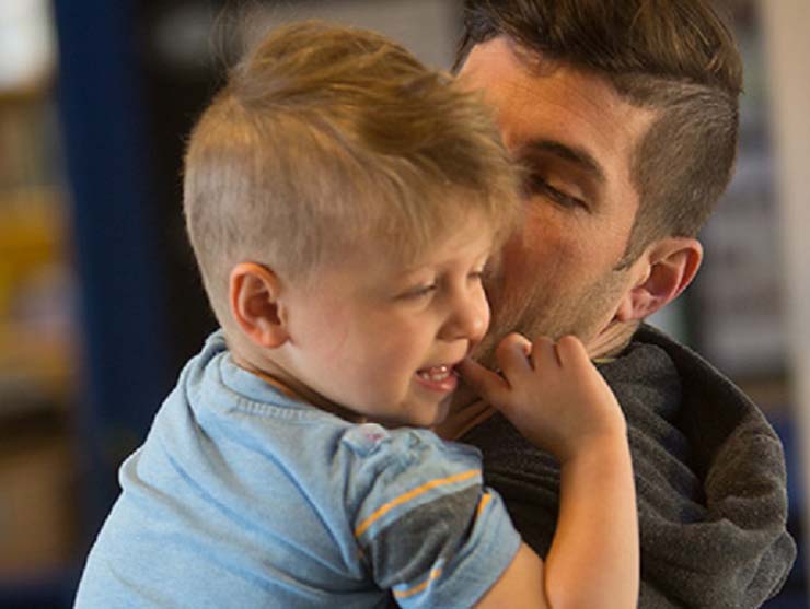 young lgbtq dad kissing his toddler son
