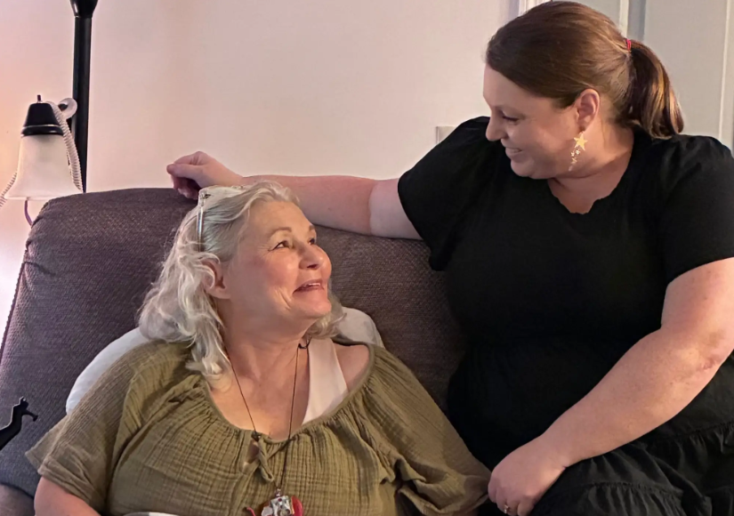 Jennifer and her mom looking at each other while sitting on the couch.