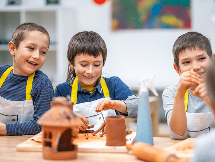 Three kids at camp making art