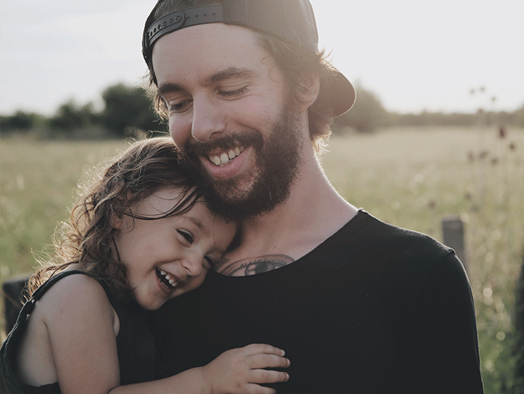 A father and daughter happily hugging.