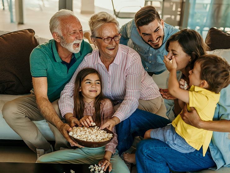Family members of all ages gathered and laughing in a living room.