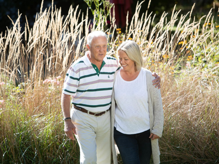 An elderly couple walking in nature