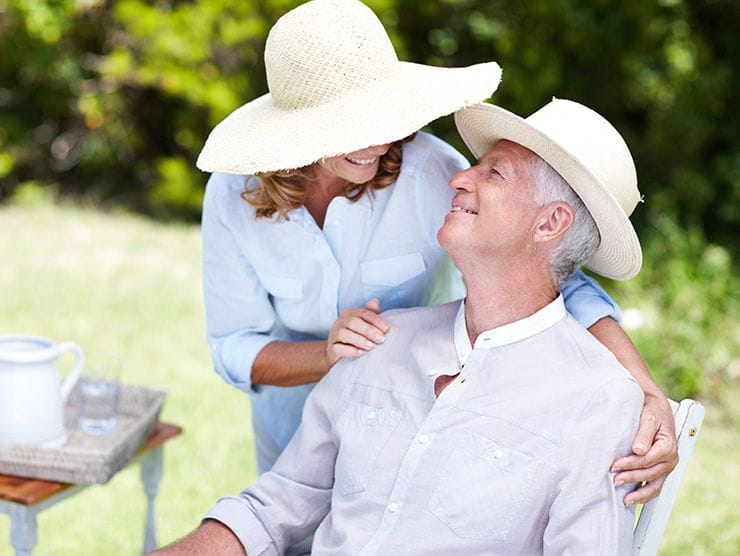 A woman holding an older man's shoulders.