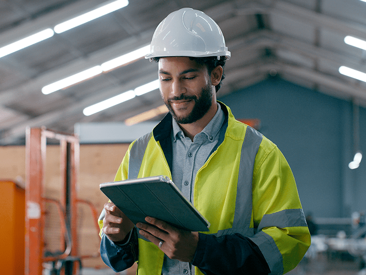 A man in work uniform reading something on his tablet screen