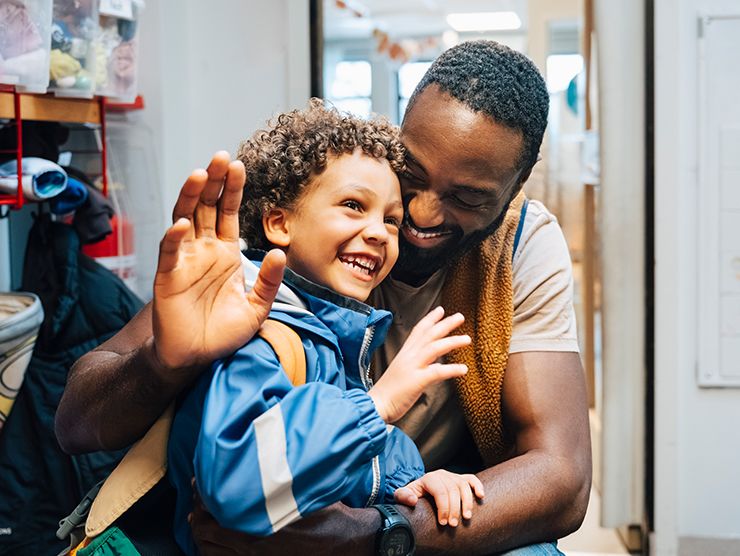 A dad hugging his child in a school setting. 