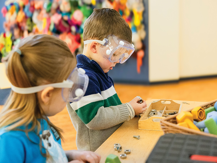 Two young children with goggles on doing an activity