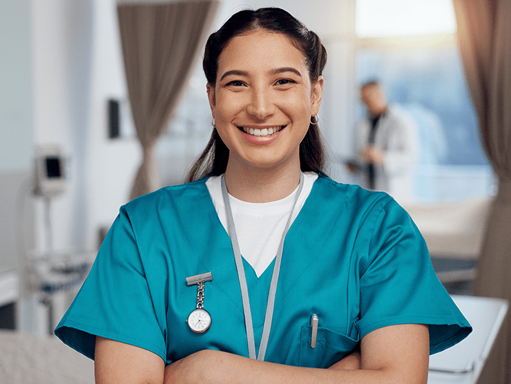 A nurse in scrubs smiling at the camera
