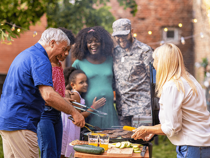 A military family eating with neighbors outdoors