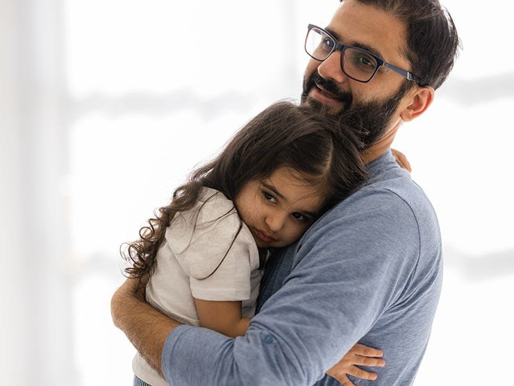 Dad hugging his shy daughter.