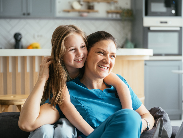 A girl hugging her mom at home. 