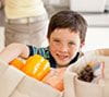 Young boy reaching into a grocery bag