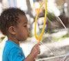Preschooler blowing a big bubble outside