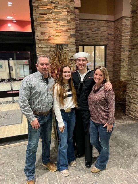 Kerri's family posing for a picture in front of a building 