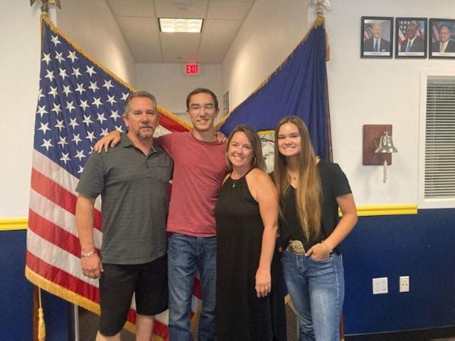 Kerri's family posing in front of American flag