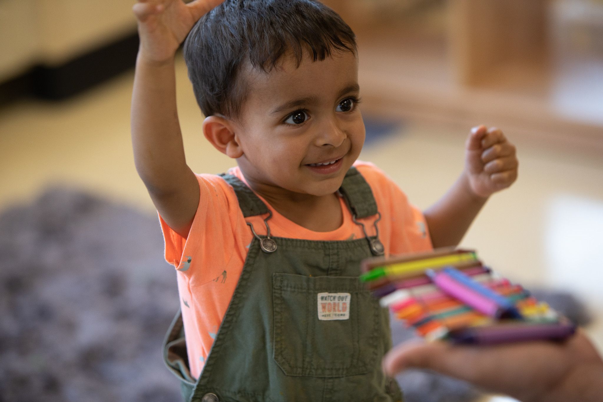 Child in overalls playing in child care center