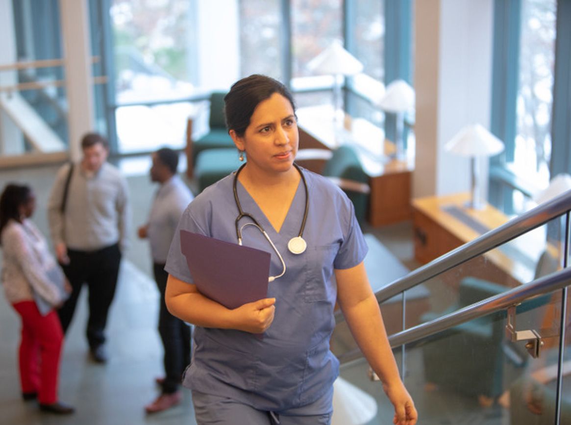 A nurse walking up the stairs.