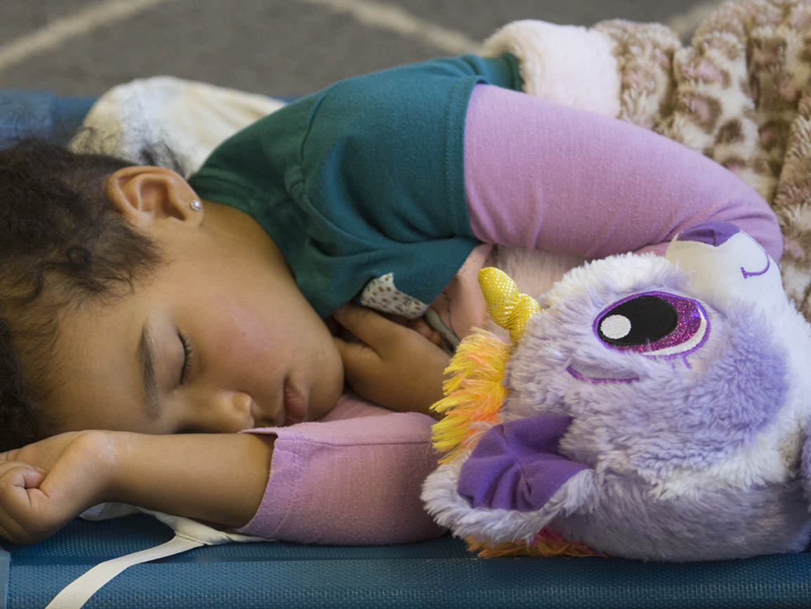 A child sleeping with her stuffed animal