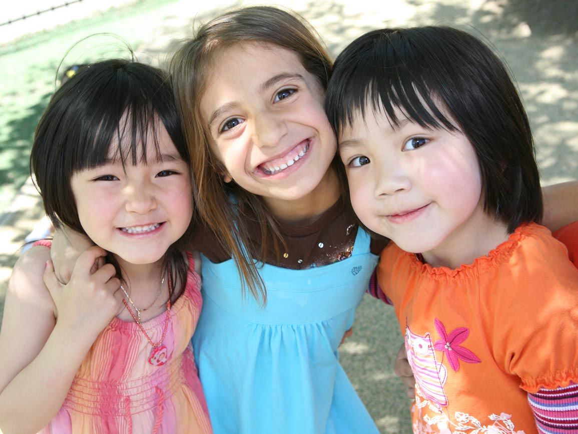 3 toddler girls smiling together