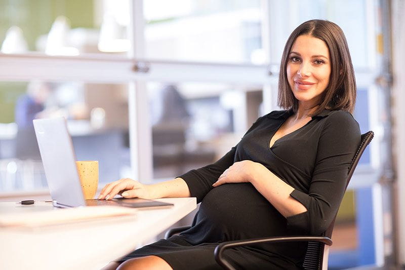 Pregnant CEO working on her laptop