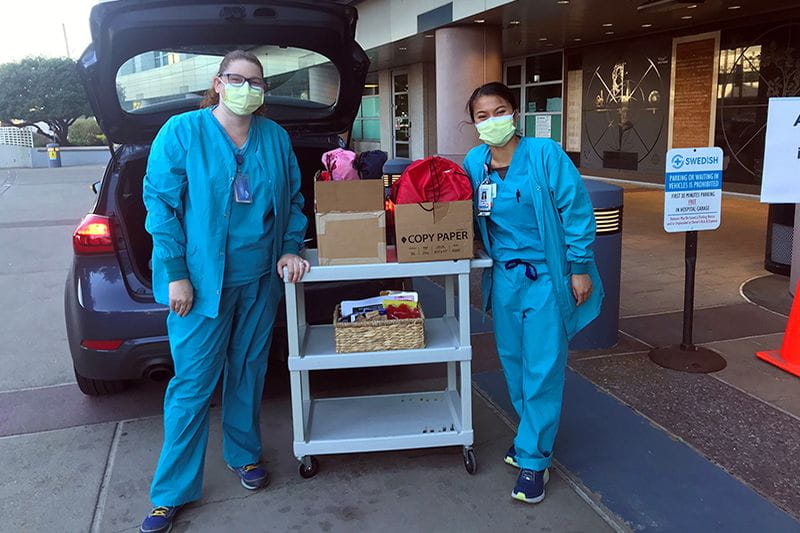 Two nurses unloading care packages
