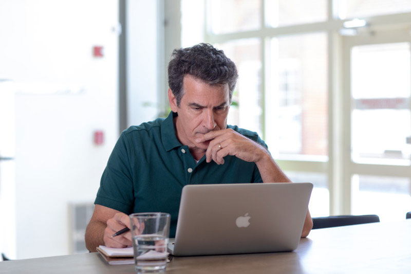 Male employee looking at his finances on his laptop