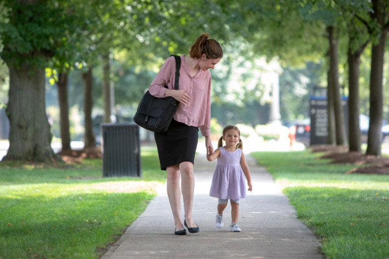 Working mom in leadership walking her daughter home from daycare