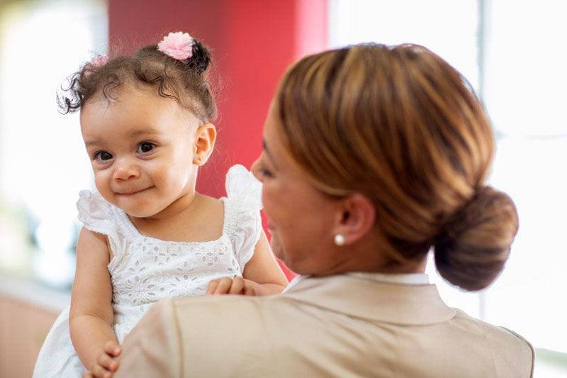 Working mom holding her baby after returning to work after leave