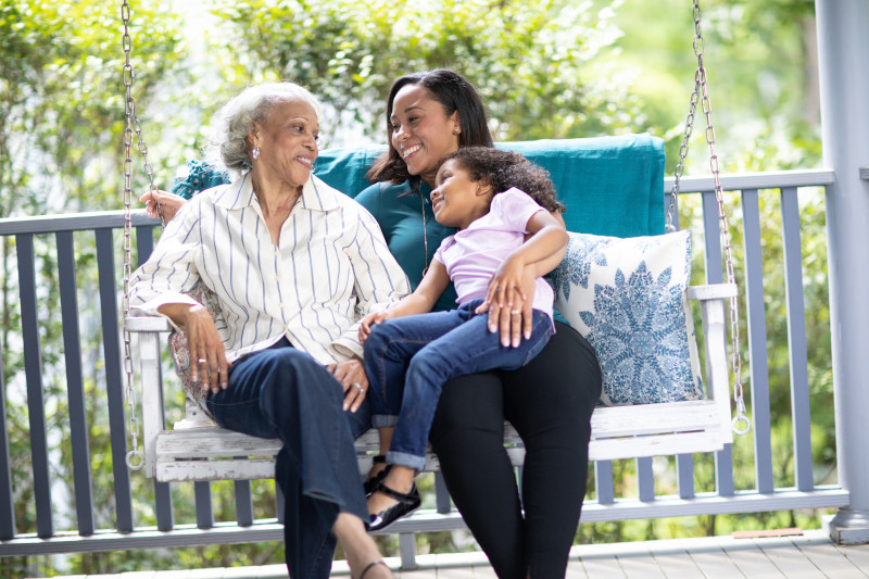 Three generations of women on an outdoor swing