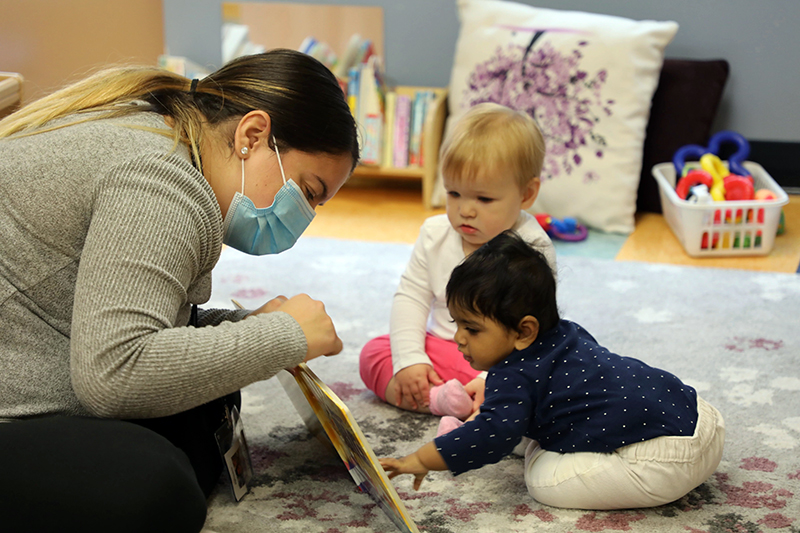 Early childhood education teacher reading to infants