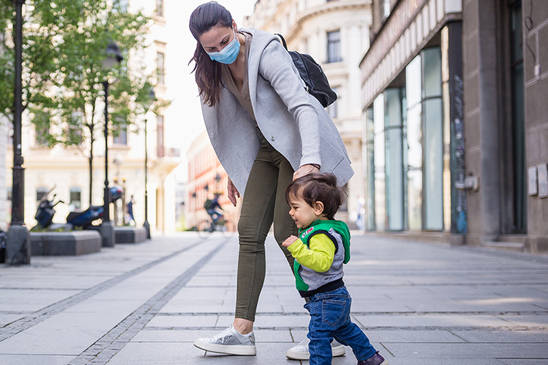 Working mom taking her child to daycare during a pandemic