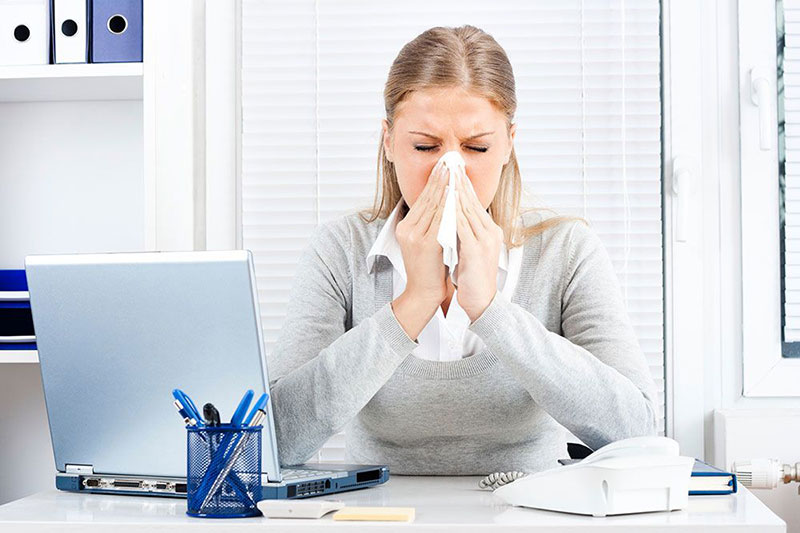 Woman sick with the flu still trying to work
