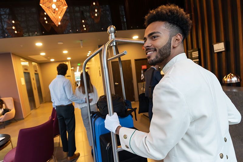 Male bellhop assisting with luggage at a hotel