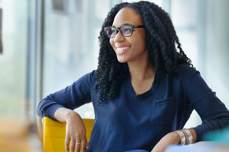 Young female looking happy and mindful at work