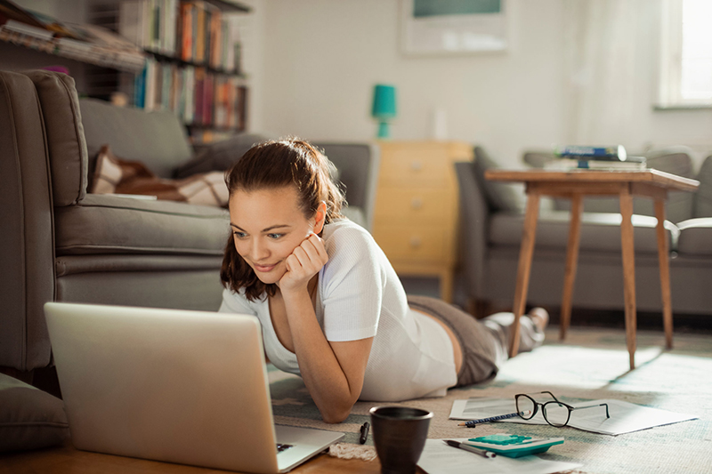 Young female professional working from home in pajamas