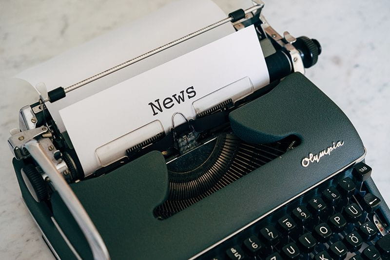 Typewriter with paper that says "news"