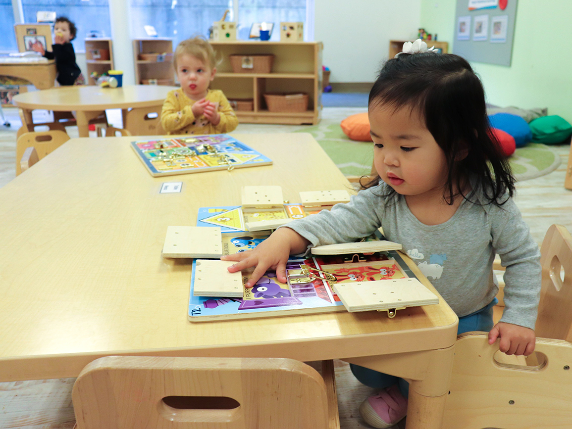 Three children playing in brightly lit child care center