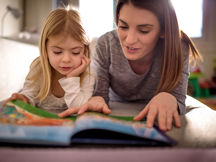 mom reading book to her daughter