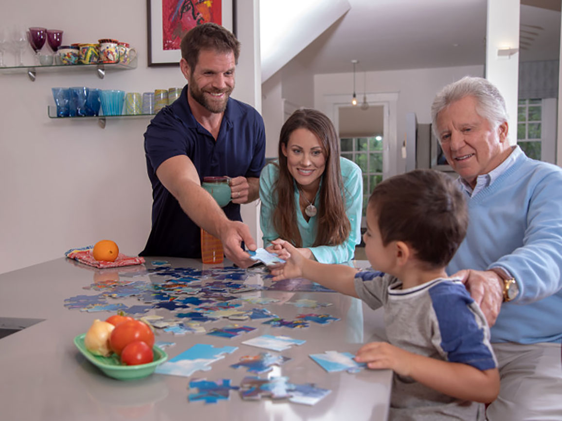 Family doing a puzzle together at the kitchen counter