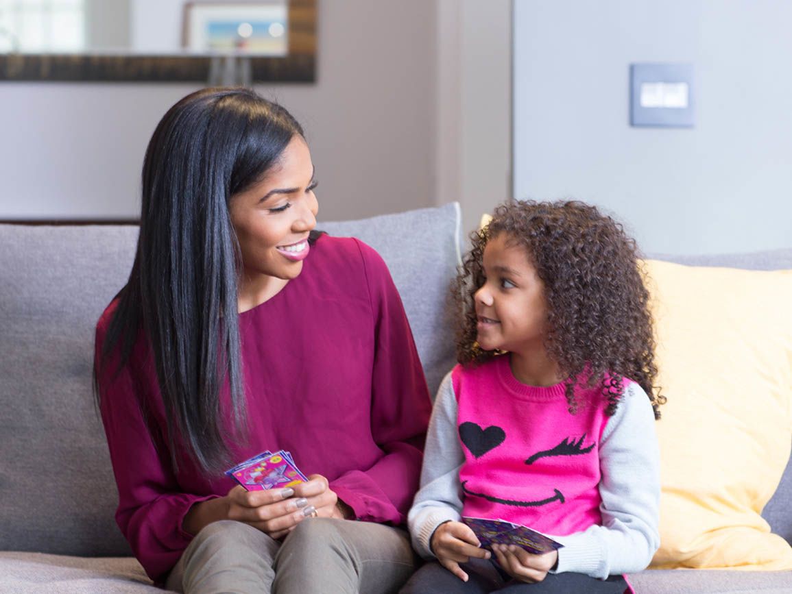 A mother and daughter playing a card game together