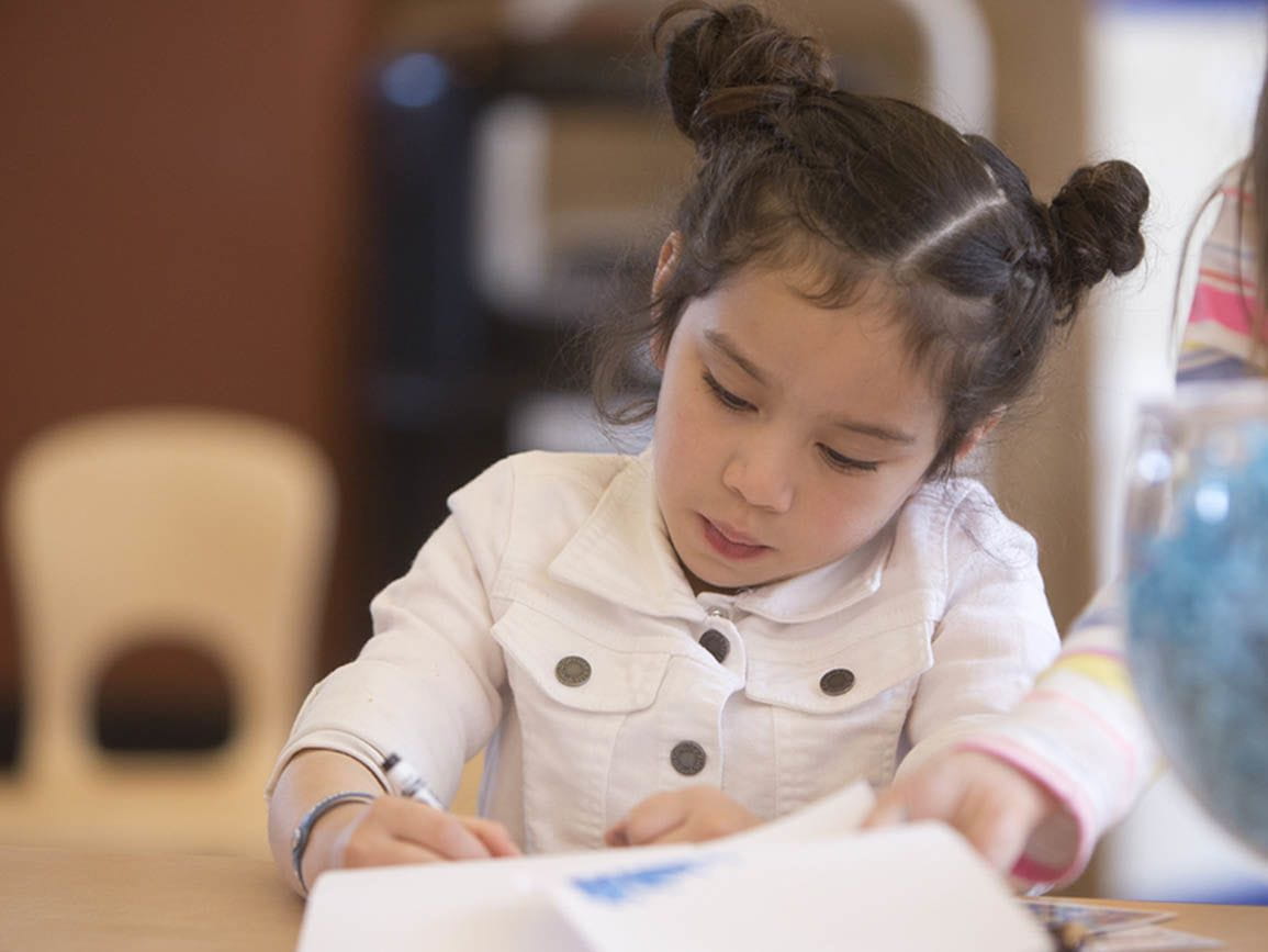 Kindergarten girl reading a book