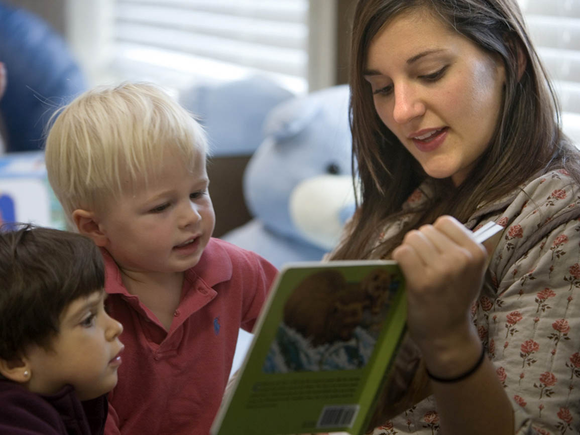 Teacher reading book to toddlers