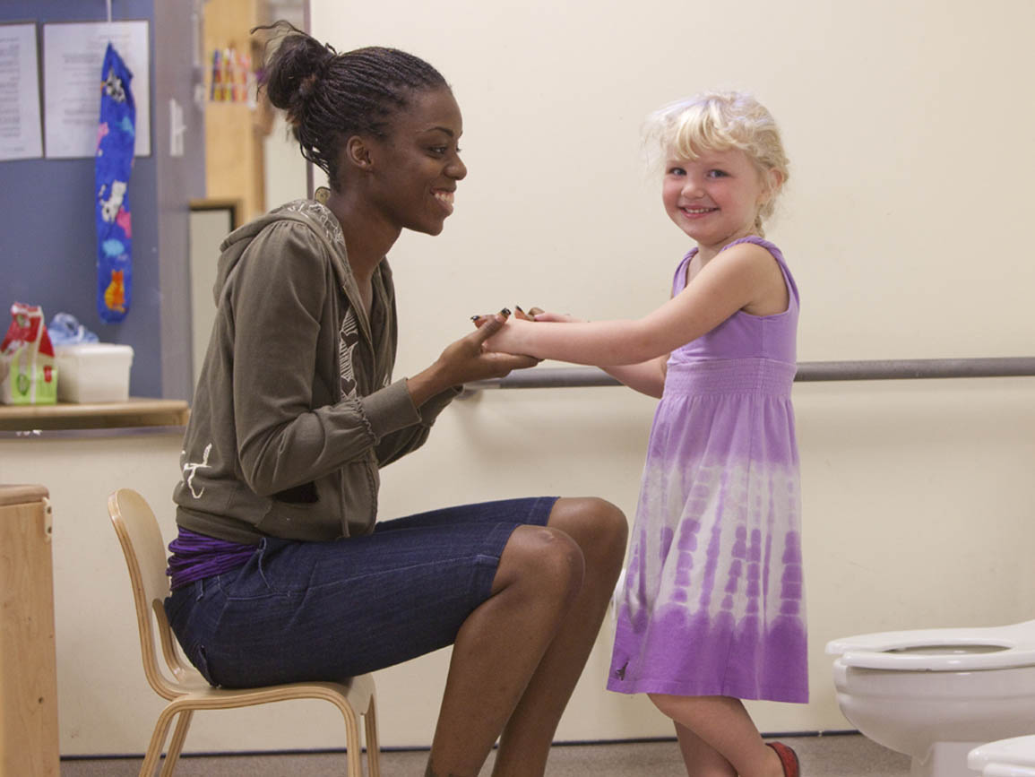 A child care teacher helping a student with potty training